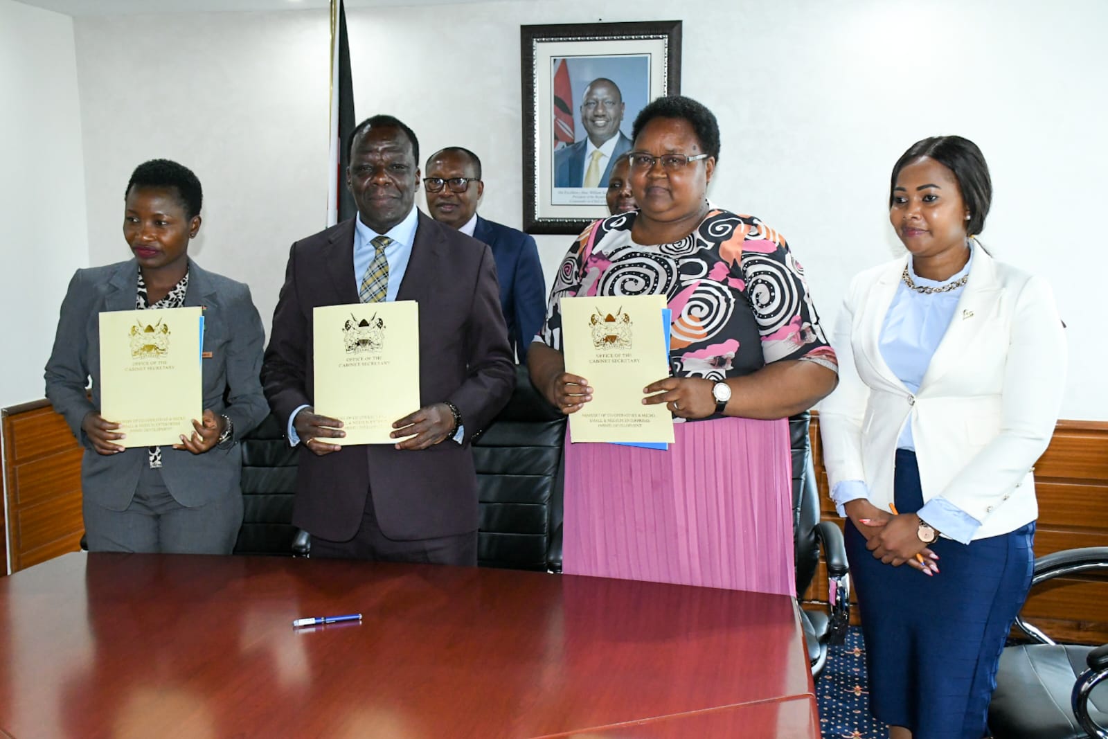 Stakeholders pose for a photo after signing of the performance contract