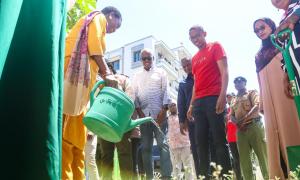 Hon. Susan Mang'eni CBS waters a tree at the Uwezo Fund Loan disbursment forum